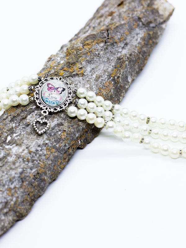 ARIEL weiße Perlenkette Kropfkette mit silbernen Zwischenperlen mit Schmetterlingsmotiv "love" und kleinem Herzanhänger - Riemenschneider Manufaktur