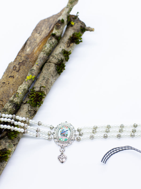 BRITTA weiße Perlenkette Kropfkette mit silbernen Zwischenperlen mit blauem Vogelmotiv Gemme und kleinem Herzanhänger - Riemenschneider Manufaktur